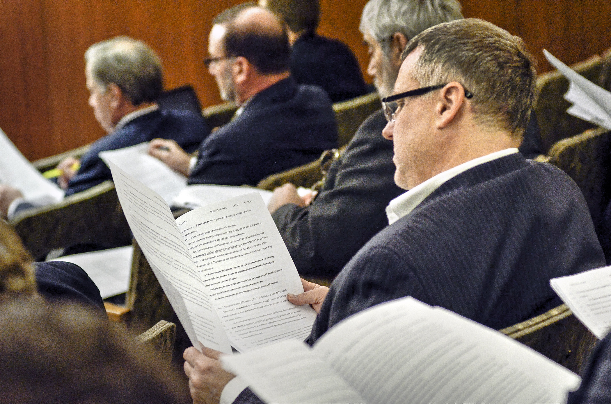 Lobbyists and interested persons peruse through the omnibus agriculture finance bill before an April 10 walk-through of the bill.  Photo by Andrew VonBank